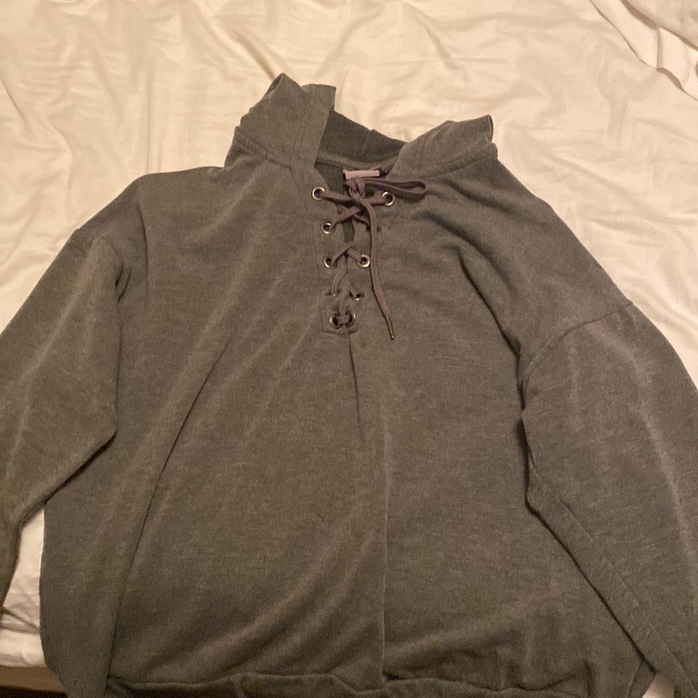This is a gray hoodie with strings in the middle